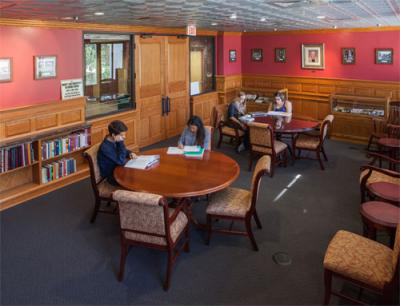 Interior view of the Norwood reading room, with patrons reading at two large round tables